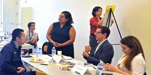 Men and women sit at a table during a learning course.